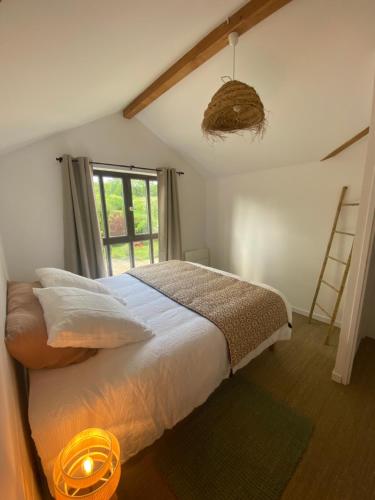 une chambre avec un lit et une fenêtre dans l'établissement Moulin de la Bourgade : L’Olivier, à Grézillac