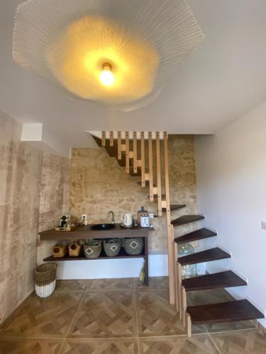 un salon avec un escalier et un plafond jaune dans l'établissement Moulin de la Bourgade : L’Olivier, à Grézillac