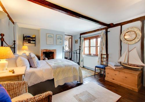a bedroom with a bed and a clock on the wall at Old Post Office Cottage in Poringland
