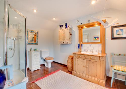 a bathroom with a shower and a sink and a toilet at Old Post Office Cottage in Poringland