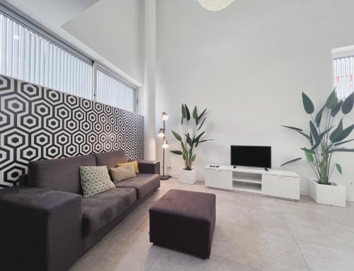 ein Wohnzimmer mit einem Sofa und einem TV in der Unterkunft Stay U-nique Apartments Pellaires in Barcelona
