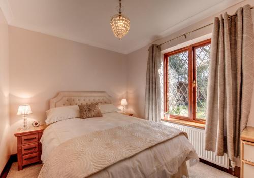 een slaapkamer met een bed en een raam bij Nursery Cottage in Clippesby