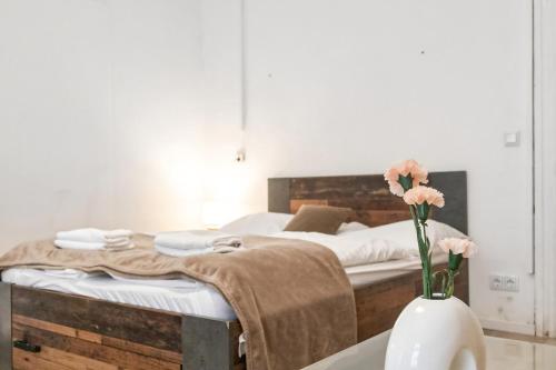 una camera da letto con un letto e un vaso con fiori su un tavolo di Vibrant 1BR - Ideal Long Stay Accommodation a Vienna
