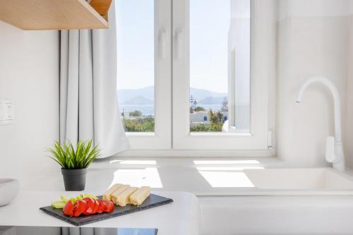 a white kitchen with a plate of food on a counter at Vino luxury suites in Agia Anna Naxos