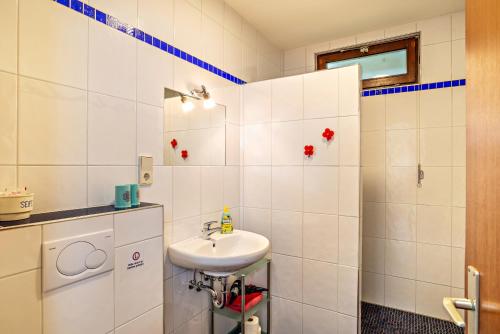 a white bathroom with a sink and a mirror at Ferienwohnung Fasse in Bühlertal