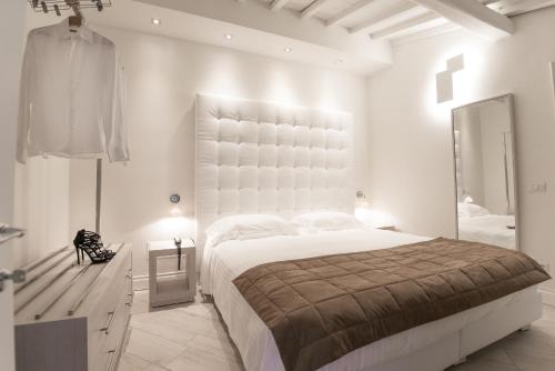 a white bedroom with a large bed and a mirror at MyForte Relais de Charme & SPA in Florence