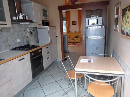 uma cozinha com electrodomésticos brancos e uma mesa e cadeiras em Appartamento con incantevole vista mare em Livorno
