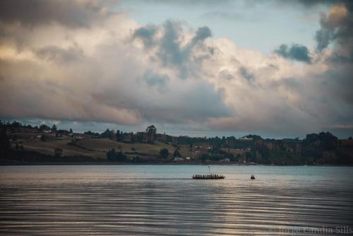 a boat in the middle of a large body of water at Cabañas Reflejo de Luna in Castro