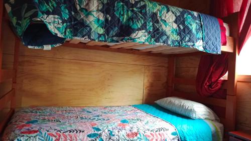 a bed in a room with a bunk bed in a room at Cabañas Reflejo de Luna in Castro