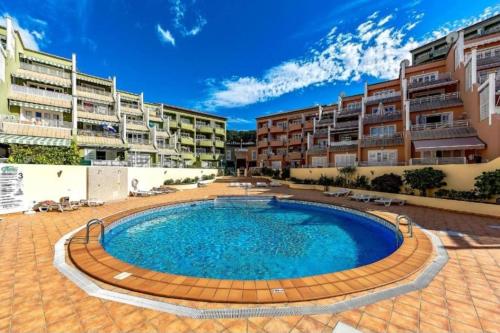 a large swimming pool in a courtyard with apartment buildings at ORLANDO LUXURY APARTAMENT in Adeje