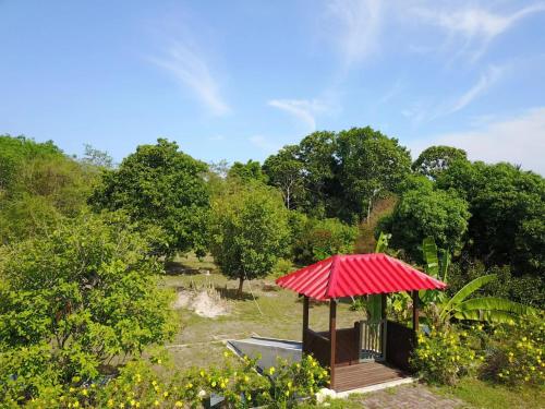 un cenador con techo rojo en un parque en My Excel Garden Mini Glass Villa with Forest View, en Air Hangat