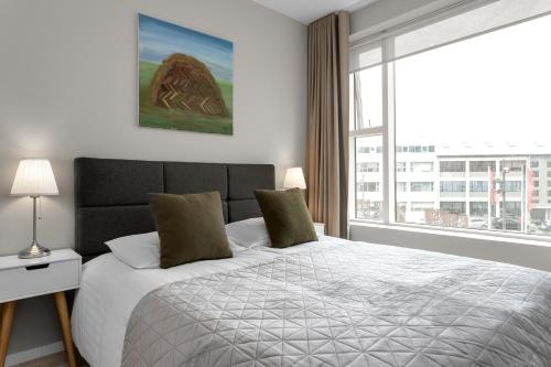 a bedroom with a bed and a large window at Tower Apartments in Reykjavík