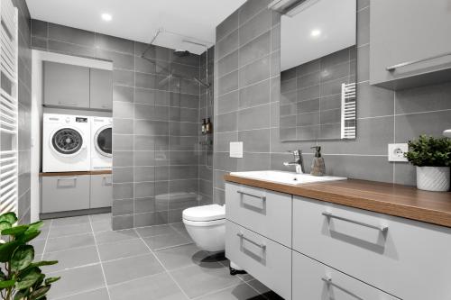 a bathroom with a toilet and a washer and dryer at Tower Apartments in Reykjavík