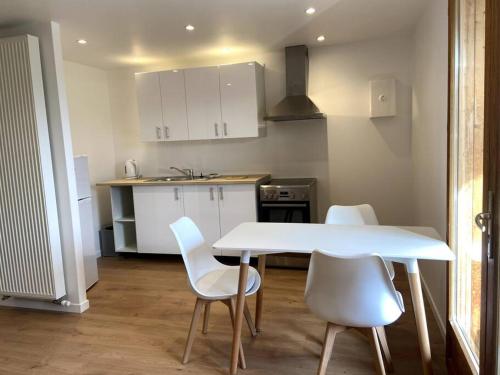 - une cuisine avec une table blanche et des chaises blanches dans l'établissement STUDIO, à Montmin