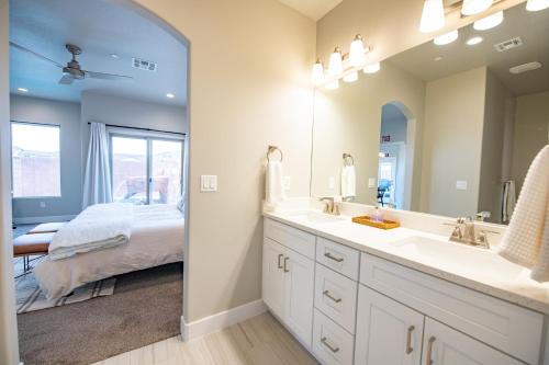 a bathroom with a sink and a bed in a room at The Pad Spacious Luxury Retreat Sleeps 23, Private Pool, Spa, Game Room and More in Hurricane