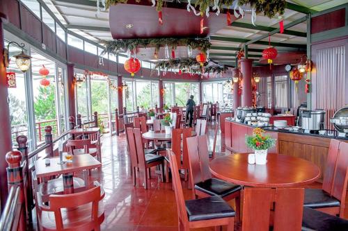a restaurant with wooden tables and chairs and a bar at Taman Simalem Resort in Tongging