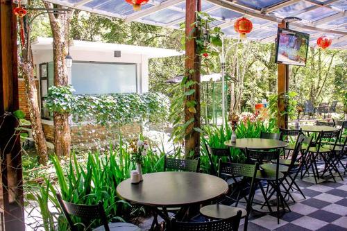 a patio with tables and chairs and plants at Taman Simalem Resort in Tongging