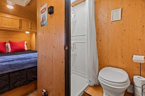 a bathroom with a toilet and a shower and a bed at JT Village Campground - Sun Ray in Joshua Tree