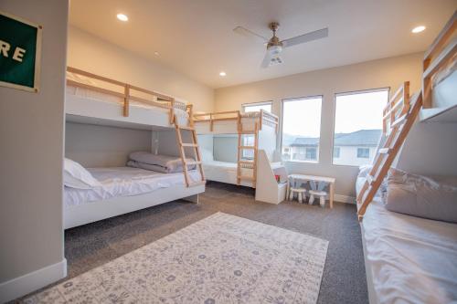 a bedroom with two bunk beds and a desk at The Pad Spacious Luxury Retreat Sleeps 23, Private Pool, Spa, Game Room and More in Hurricane
