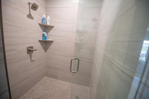 a bathroom with a shower with a glass door at The Pad Spacious Luxury Retreat Sleeps 23, Private Pool, Spa, Game Room and More in Hurricane