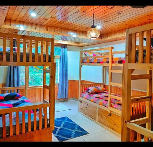 a bedroom with three bunk beds in a cabin at Zebra Hostels in Varkala