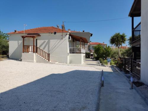 a white house with a red roof on a street at Elina House and Garden in Nikiti