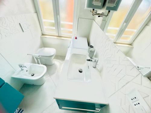 a white bathroom with a sink and a toilet at Suite LEI - Sanremo in Sanremo
