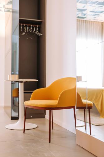 a yellow chair in a room with a table at Biancodonda Greenblu Hotel & SPA in Gallipoli