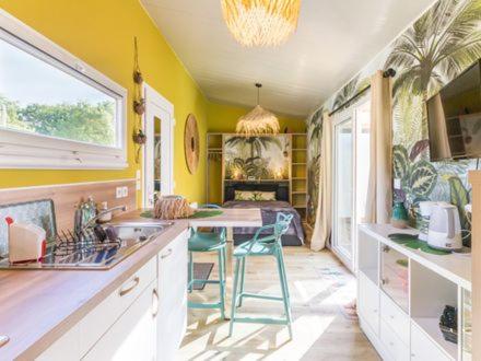cocina con paredes amarillas, mesa y sillas en Copacabana TINY HOUSE studio terrasse jardin en Saint-Aignan-Grand-Lieu