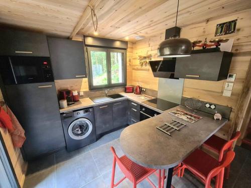eine Küche mit einem Waschbecken und einem Tisch mit Stühlen in der Unterkunft Le Refuge perché du saut de la bourrique SPA Gérardmer in Gérardmer
