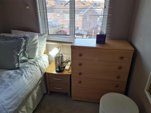 ein Schlafzimmer mit einem Bett, einer Kommode und einem Fenster in der Unterkunft Sturry House in Sturry