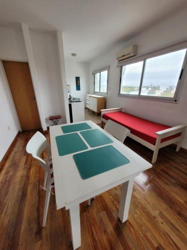 ein Wohnzimmer mit einem Tisch und einer roten Bank in der Unterkunft Luminoso Monoambiente in La Plata