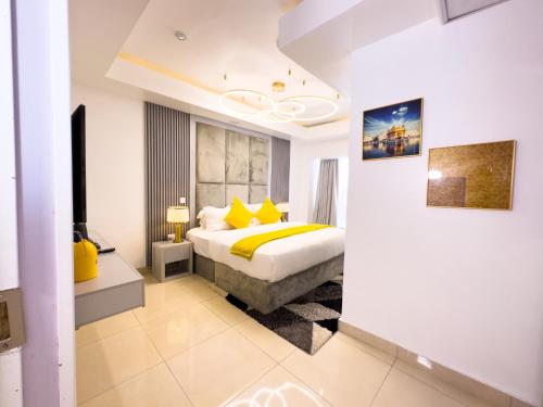 a bedroom with a bed with yellow pillows at The Gibs Hotel Limited in Port Harcourt