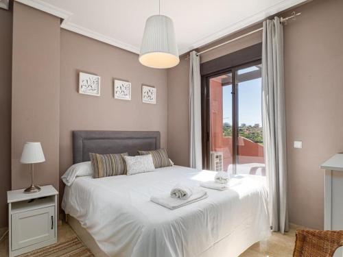 a bedroom with a white bed and a large window at Penthouse Majestic Costa Golf Casares in Casares