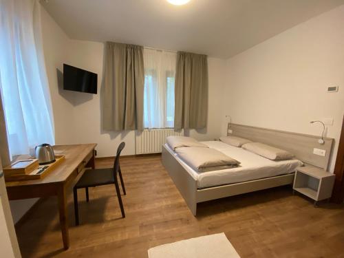 a bedroom with a bed and a desk and a table at Vera Park & Wellness in Belluno