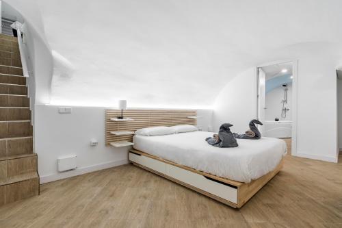 a bedroom with a bed with two penguins sitting on it at El triangulo del Arte - Jacuzzi in Madrid