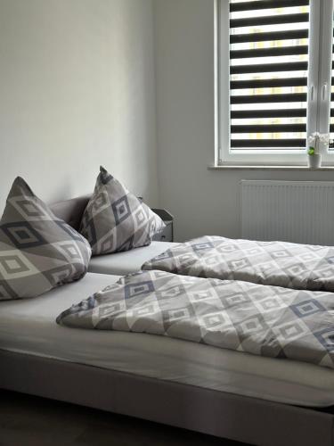 ein Bett mit Kissen darauf im Schlafzimmer in der Unterkunft Ferienwohnung Centro in Bremerhaven