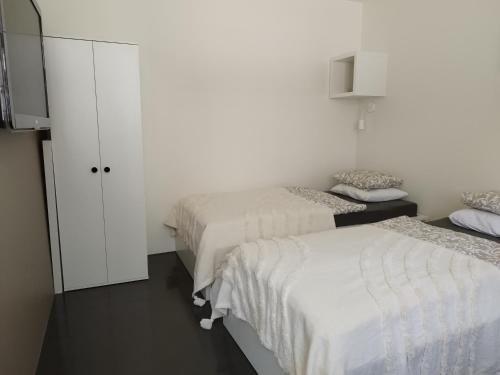 2 Betten in einem Zimmer mit weißen Wänden in der Unterkunft Courtyard Condo Twin in Liepāja