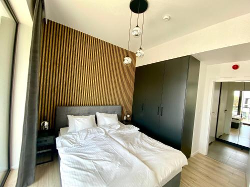 a bedroom with a large white bed with a wall at Rogowo Prestige Shellter in Rogowo