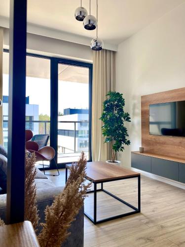 a living room with a table and a couch at Rogowo Prestige Shellter in Rogowo