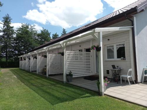 a house with a deck with awnings on it at Apartamenty Na Wschodniej in Chłopy
