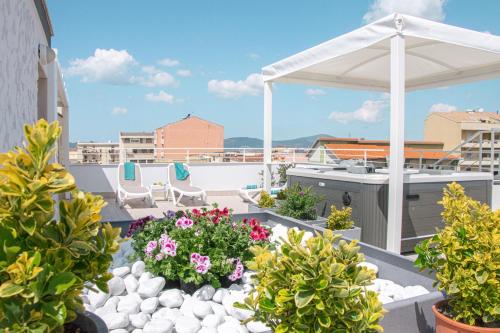 a patio with flowers and plants on a roof at Skyfive Earth Apartment in Alghero