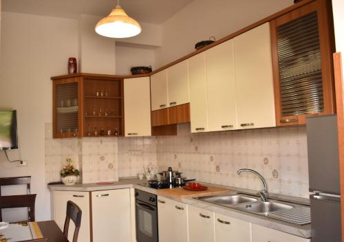 a kitchen with white cabinets and a sink at Il Giardino di Vincenzina B&B in Lauria