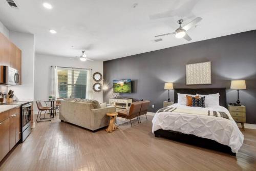 a bedroom with a bed and a couch and a kitchen at Style and Comfort Studio Southtown Gym Pool in San Antonio
