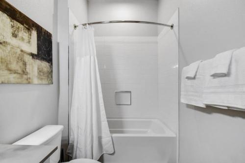 a white bathroom with a shower and a toilet at Style and Comfort Studio Southtown Gym Pool in San Antonio
