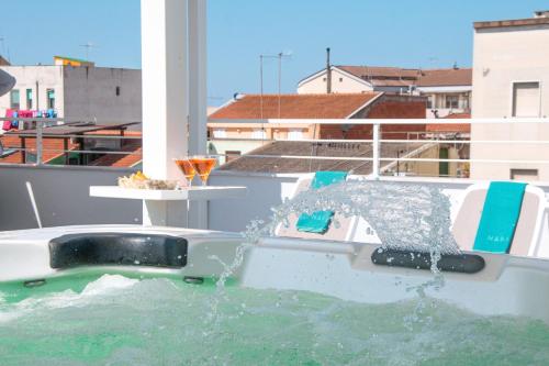 a boat in the water with water pouring out at Skyfive Earth Apartment in Alghero