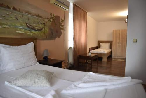 een slaapkamer met een wit bed en een woonkamer bij Pensiunea sellina in Sulina