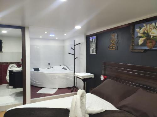 a bathroom with a tub and a bed and a bath tub at Hotel el Che No apto para corruptos in Azogues