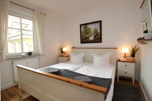 um quarto com uma cama branca e uma janela em Wohnpark Strandstraße App 12 em Wustrow