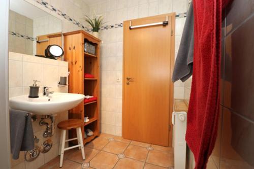 uma casa de banho com um lavatório e uma porta de duche em madeira em Wohnpark Strandstraße App 12 em Wustrow